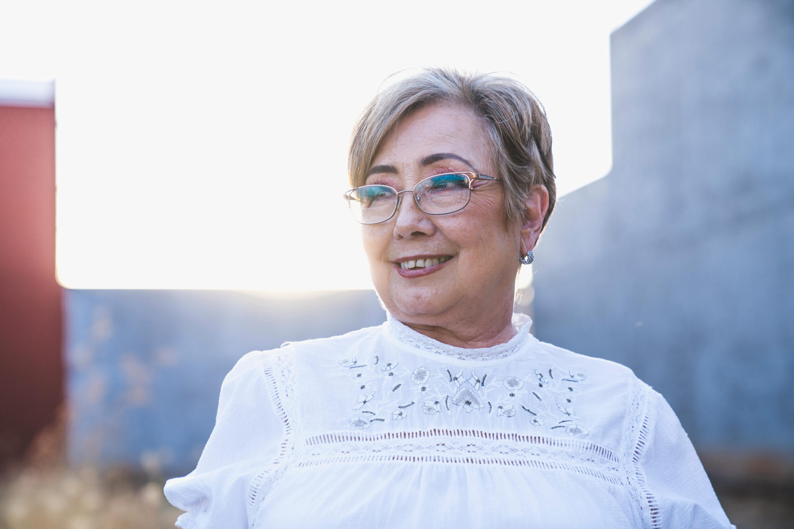 Happy older woman with healthy vision wearing glasses outdoors, symbolizing natural ways to prevent vision loss