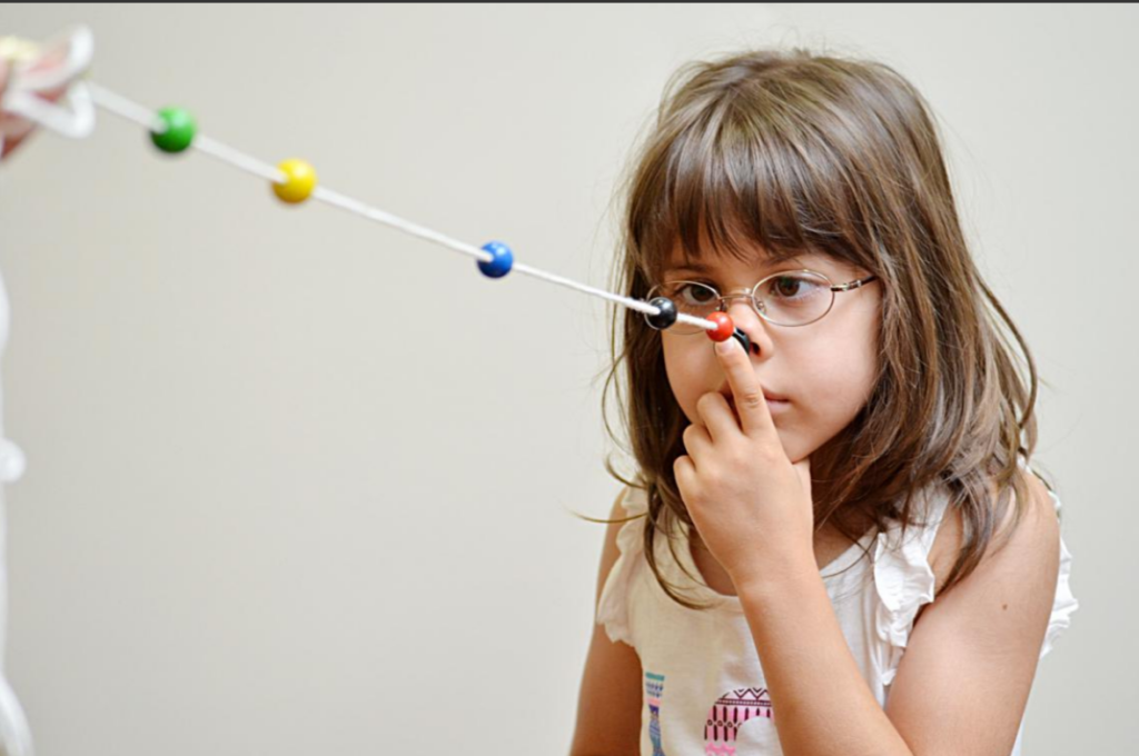 A child performing a Brock string exercise for binocular coordination and neuro visual training.
