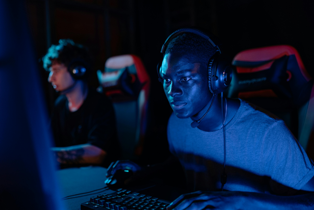 A person focusing on a computer screen with blue light reflection on their glasses, illustrating reduced blinking during screen use