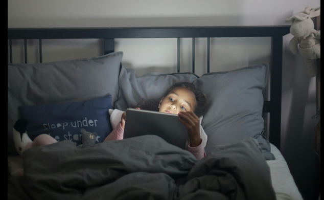 A young child rubbing tired eyes after prolonged smartphone use, representing digital eye strain.