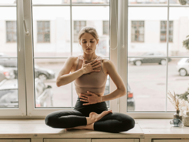 A woman meditating in natural light, symbolizing the mind–body connection for eye health
