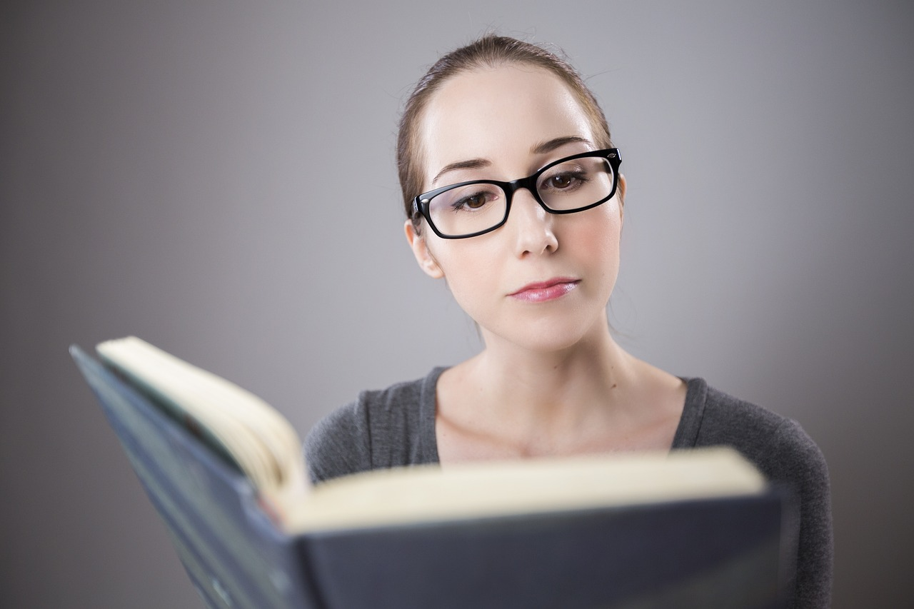 Middle-aged woman reading with glasses in natural daylight — representing age-related vision changes.”