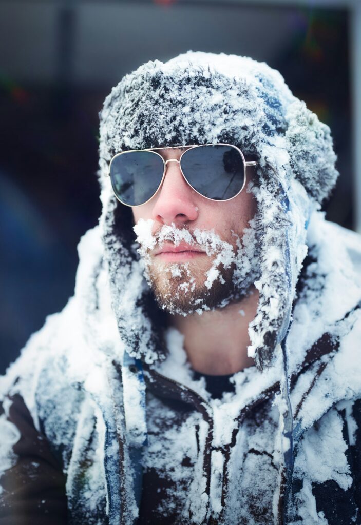 person wearing wrap around sunglasses snowy windy weather