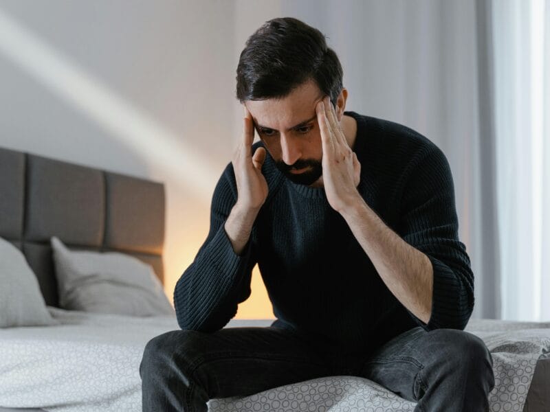 Man suffering from chronic migraine and dizziness caused by Binocular Vision Dysfunction (BVD).