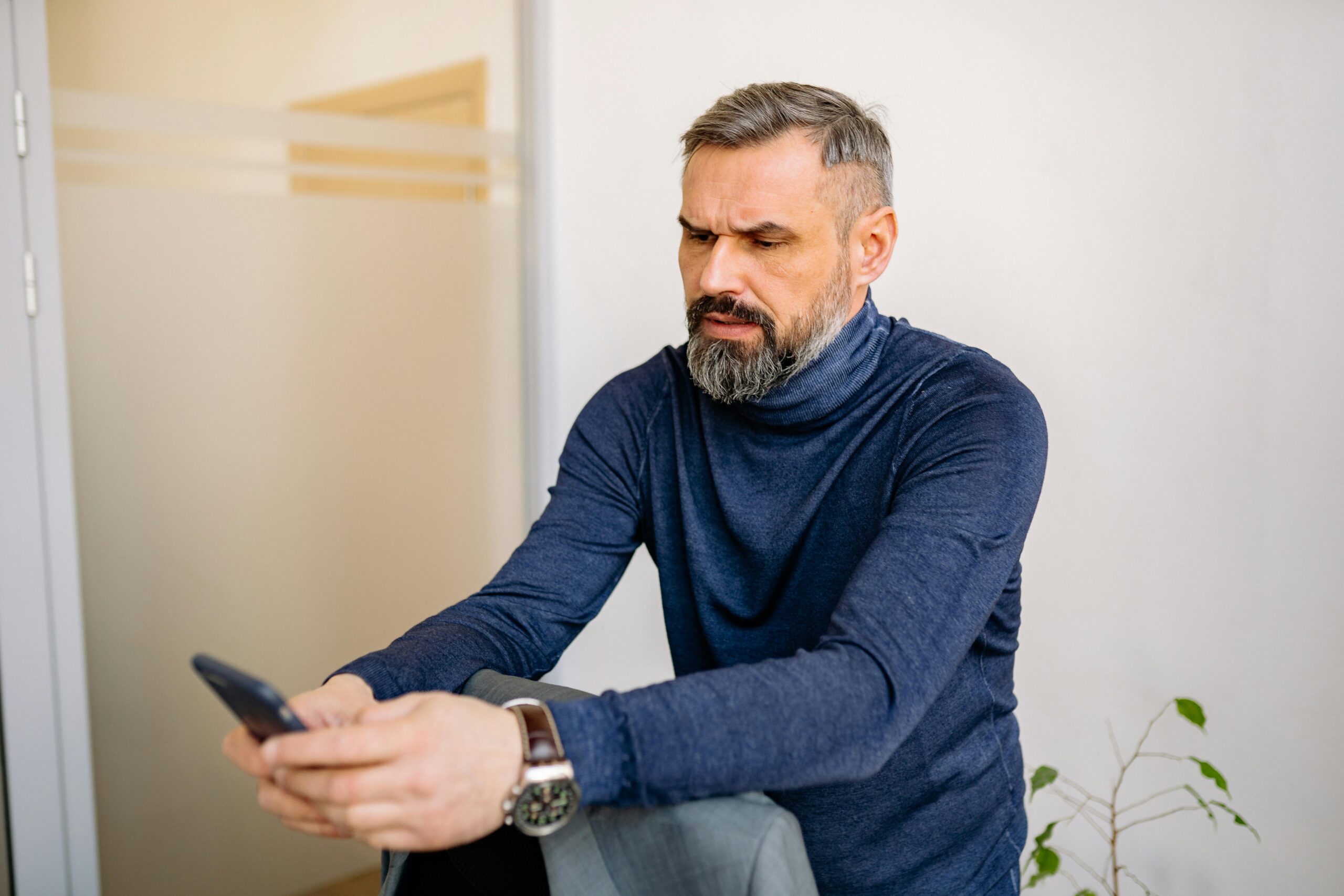 Man experiencing presbyopia symptoms while reading on a smartphone