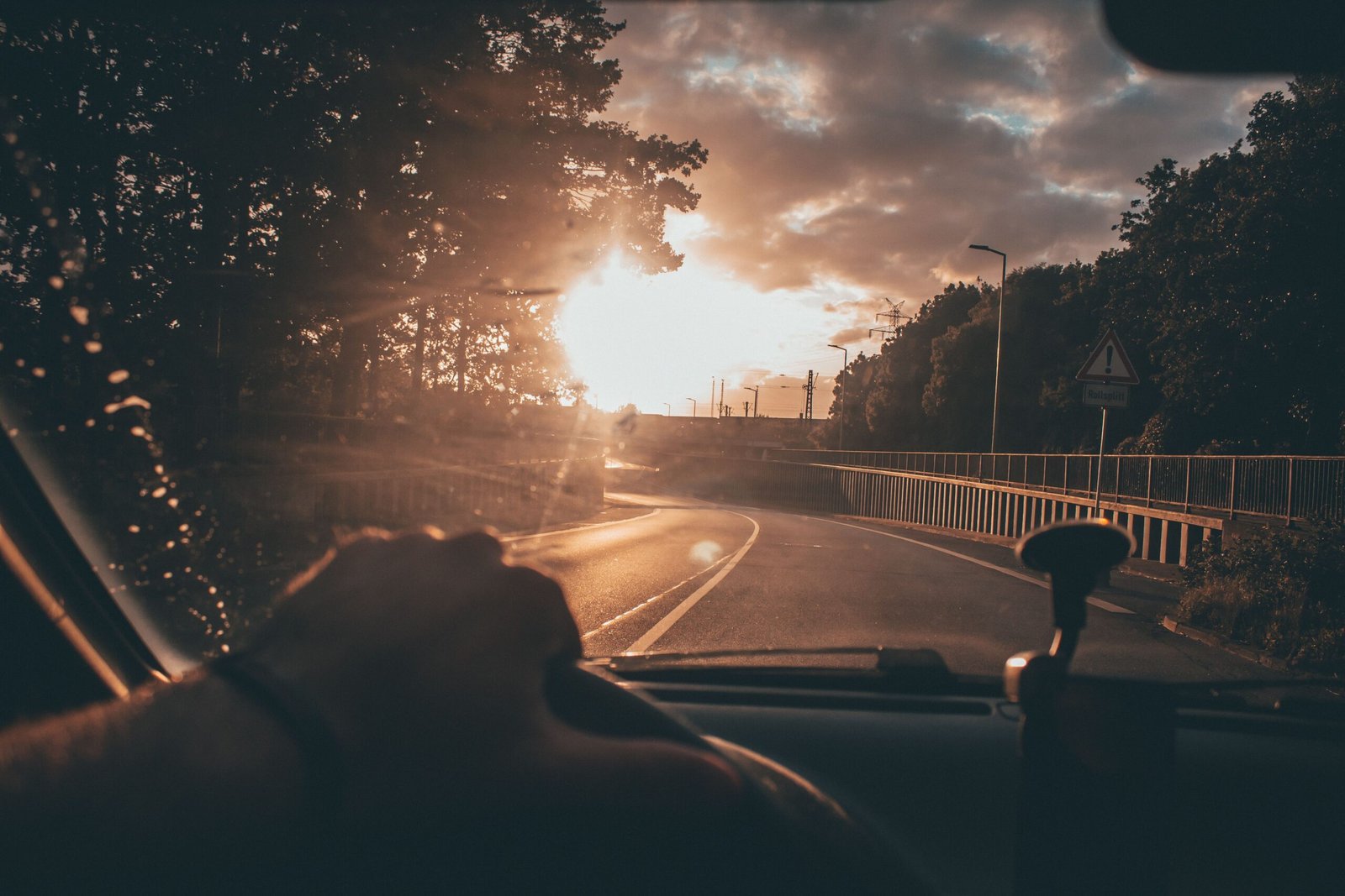 A driver experiencing driving eye strain due to bright sunlight and glare on the highway.